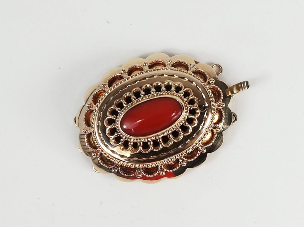 Gouden sluiting met bloedkoraal - detail van antieke sieraden uitzoeken voor authentieke aankopen