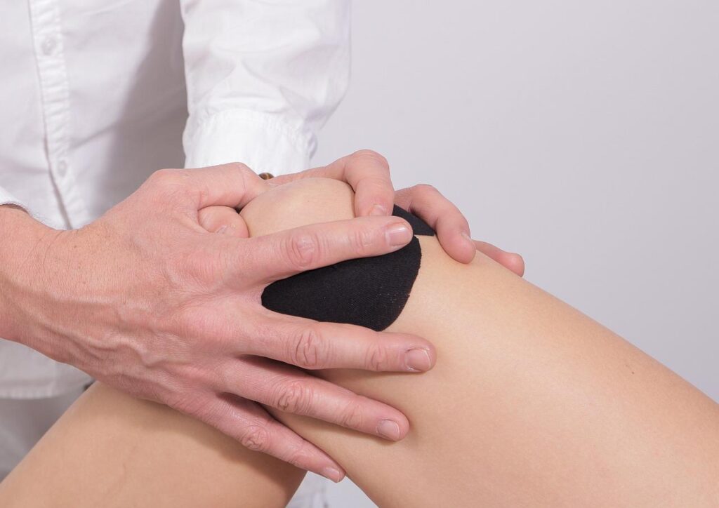 Fysio therapeut begeleidt patiënt bij herstel na nieuwe knie-operatie met gerichte oefeningen en mobilisatie